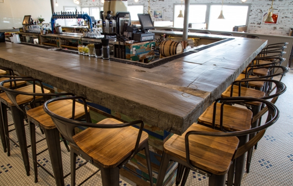 Wood look concrete bar top in a large restaurant bar.