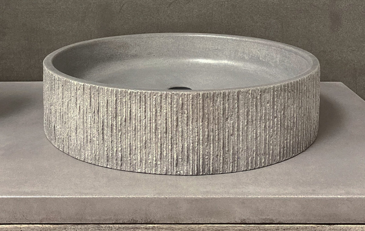 Round basin style sink in gray concrete.
