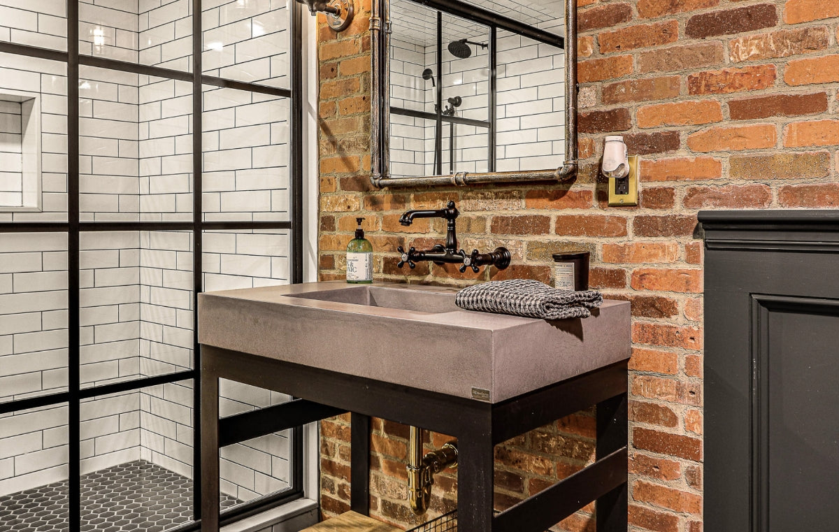 Close up of industrial styled bathroom with concrete console sink.