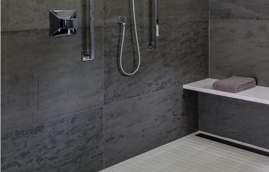 Large shower with concrete wall panels on the walls.