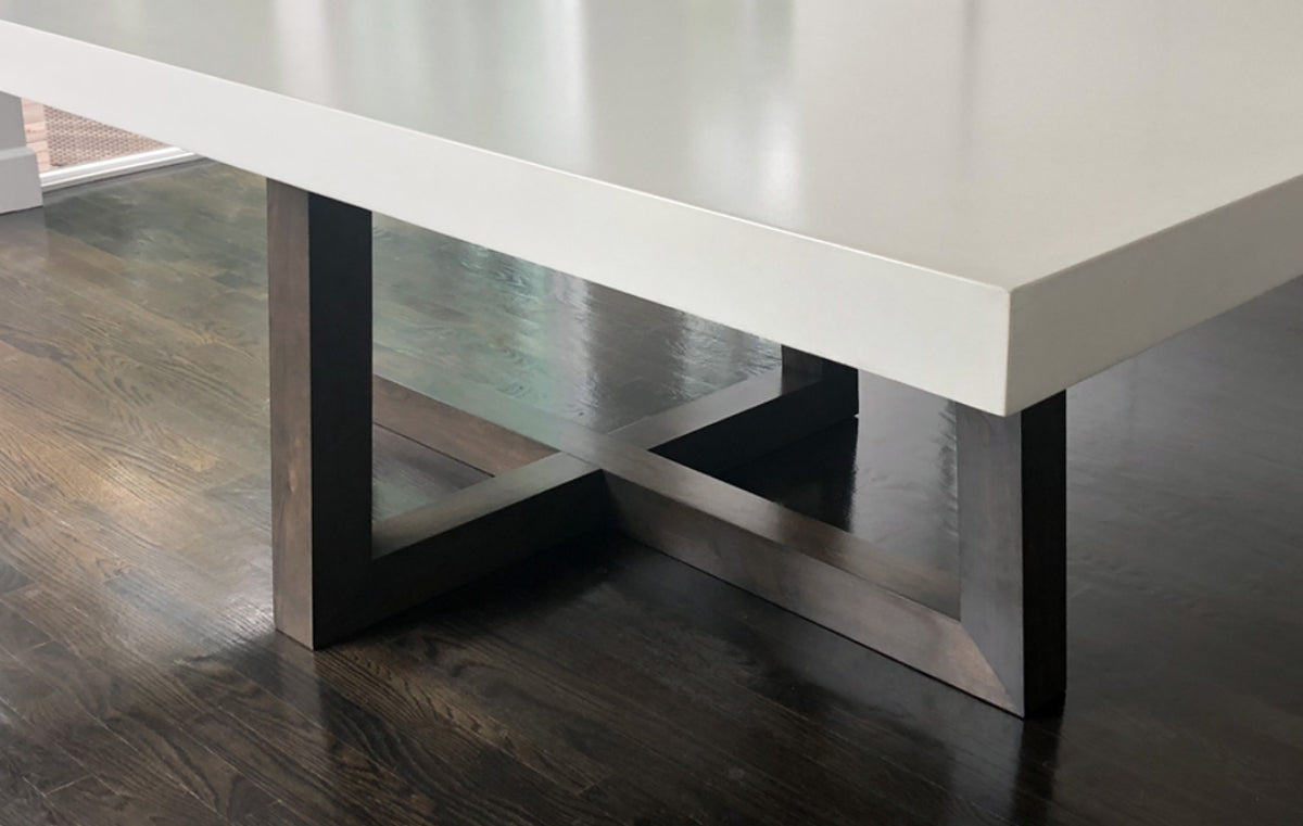 White concrete table with metal legs in a dining room with wood floors.