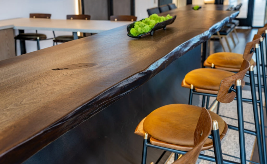 Long, seamless wood look bar top in concrete with bar stools.