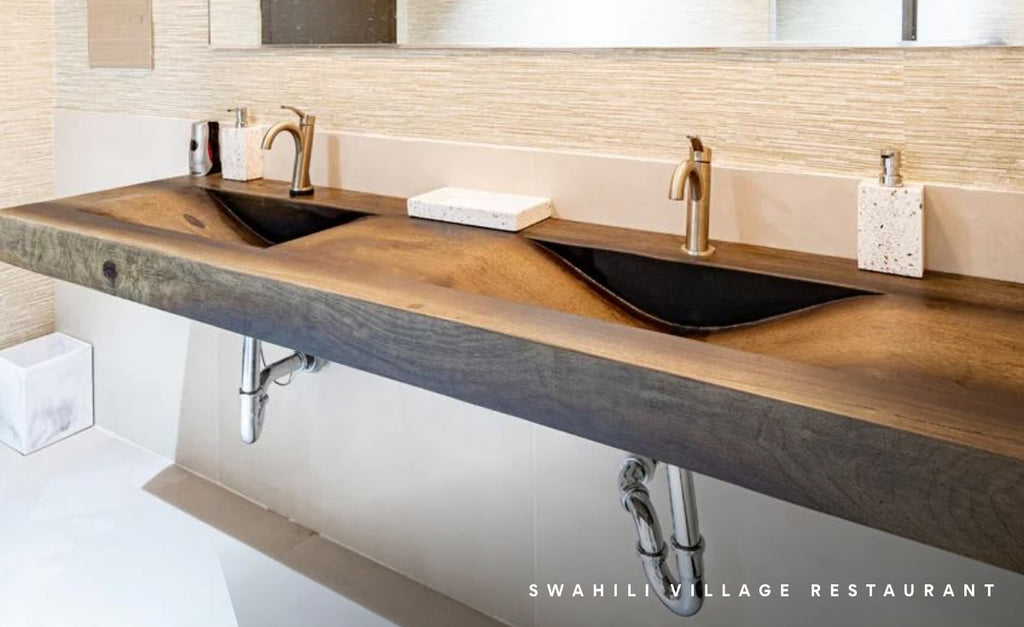 Wood look concrete sink with curved basin in a large commercial bathroom.