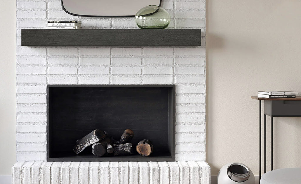 Fireplace with concrete mantel against a white brick surround.