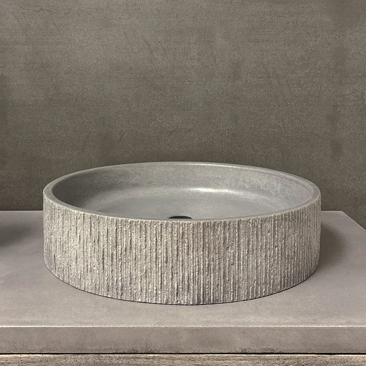 Basin bathroom sink in ribbed concrete designed by Clodagh.