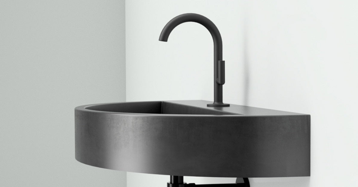 Semi-circle floating trough sink in concrete with black hardware.