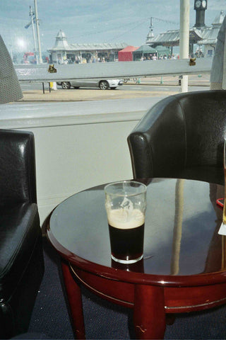 Offie Mag Travel Brighton, Brighton Travel article image showing a pint of Guinness in a sunny hotel lobby with a sea view.