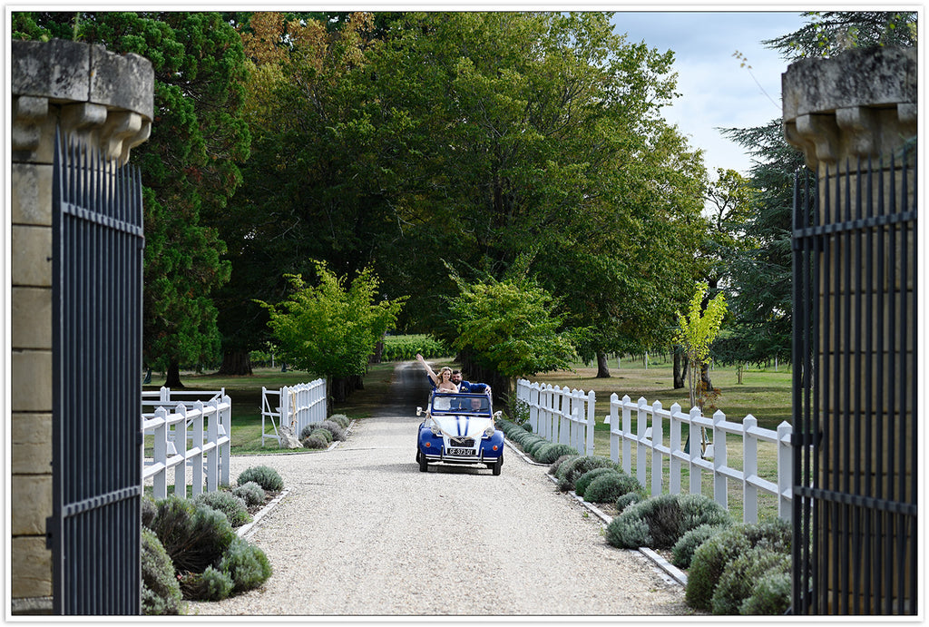 bride and groom driving off at chateau