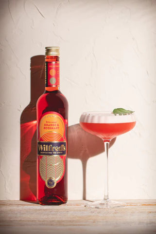 Bottle of Wilfred's displayed next to an alcohol free lime sour Fred's cocktail against a white background