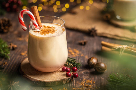 Fall Special Vegan Nog garnished with a cinnamon stick and candy cane
