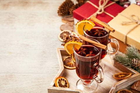 Two glasses of non-alcoholic mulled wine on a wooden tray