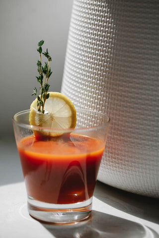 a glass of non-alcoholic fiery golden tonic on a white surface