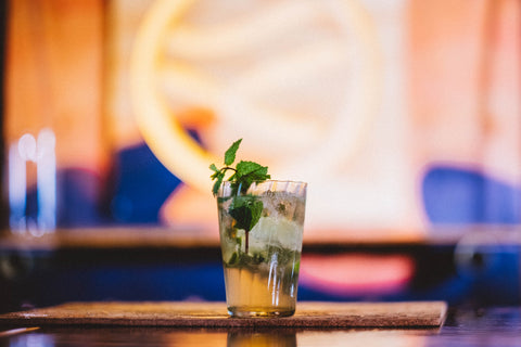 Feragaia mojito garnished with mint served in a tall glass placed on a bar with bright background