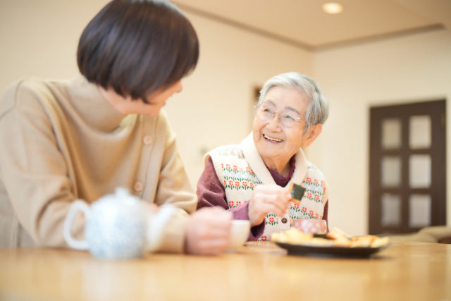 笑顔でおやつを食べる高齢者