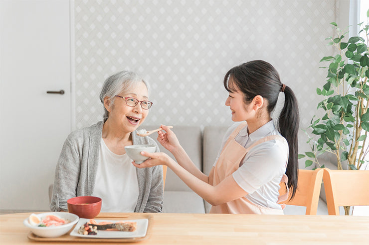 食事介助を受ける高齢女性