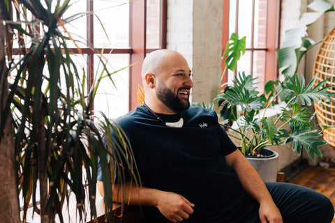 Founder, Jay Castro familian Je'je', joyfully looking towards the future with a black shirt and a sinahi necklace. .