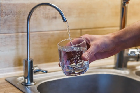 Filling glass cup with filtered tap water