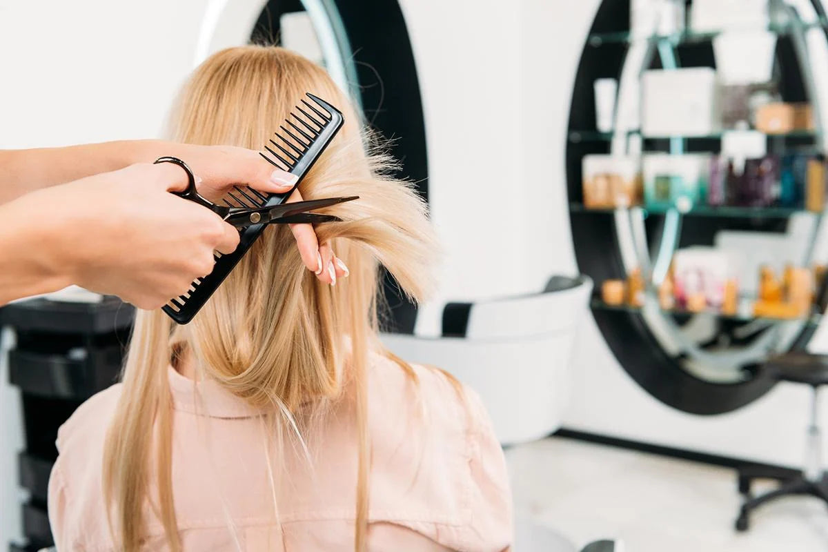 A hair stylist meticulously cutting a girl's locks, showcasing a moment of precision and artistry in this visually engaging alt text.