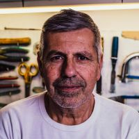 Portrait of a mature man with tools in the background.