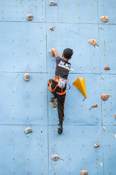 Little boy lead climbing on indoor rock climbing wall