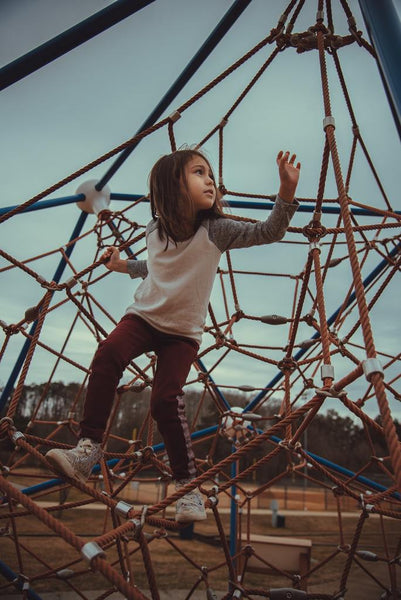 Little girl climbing on a structure in a playground