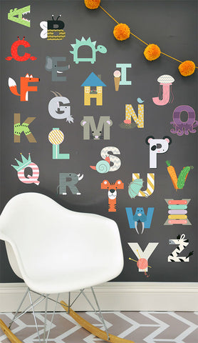 alphabet wall mural for kids on black wall with white chair and rug