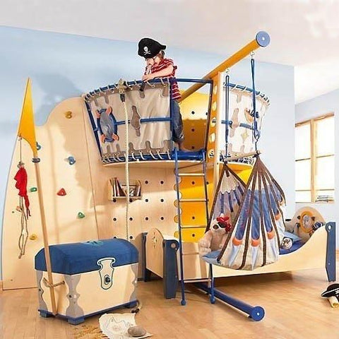 kid in a pirate ship themed playroom with treasure chest and swing