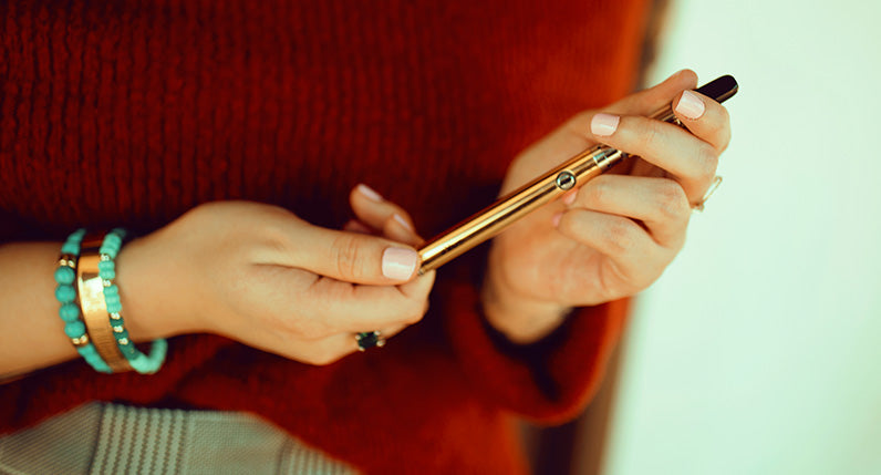 Woman with red sweater holding Exxus Twistr adjusting the voltage