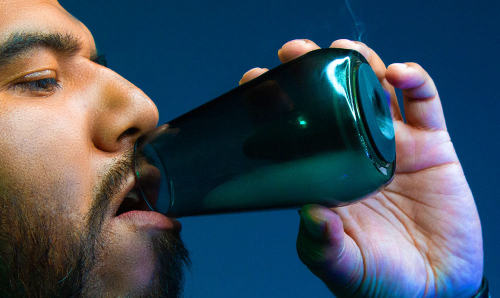 Man holding Wulf Fang with vapor inside in front of blue studio background