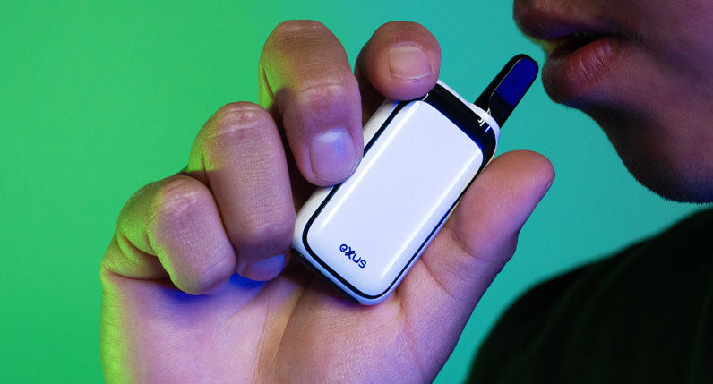 man hand holding the Exxus Rizo inside studio with green background