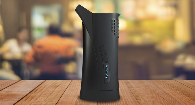 G Pen Roam Vaporizer standing on wooden table inside home.