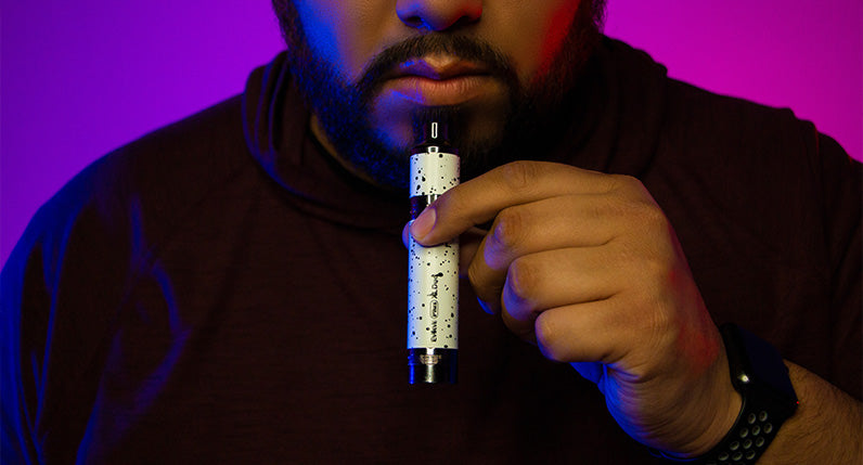man holding White and Black Spatter Wulf Evolve Plus XL Duo Concentrate Mode in studio