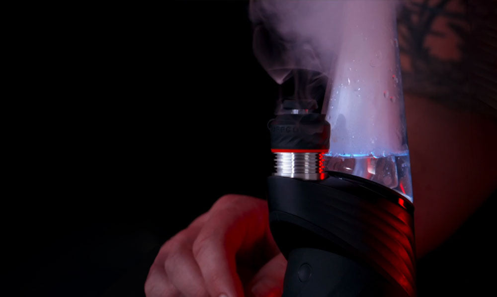 man with tattoo blowing smoke using the peak pro with 3d xl chamber