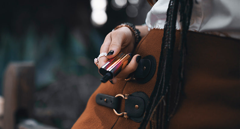 woman leaning against wooden fence holding the Sutra Auto