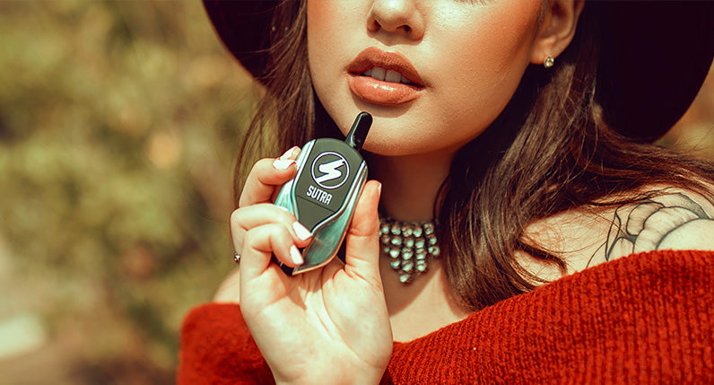 woman in red sweater holding the Sutra Squeeze at park