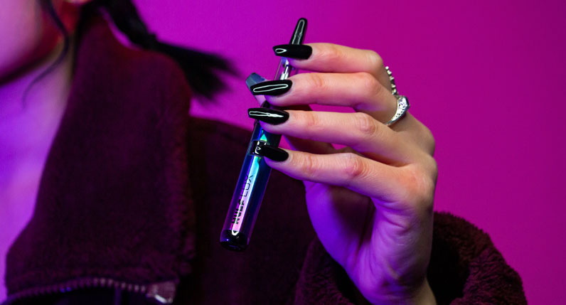 Woman with coat holding the Wulf LUX inside studio with magenta background