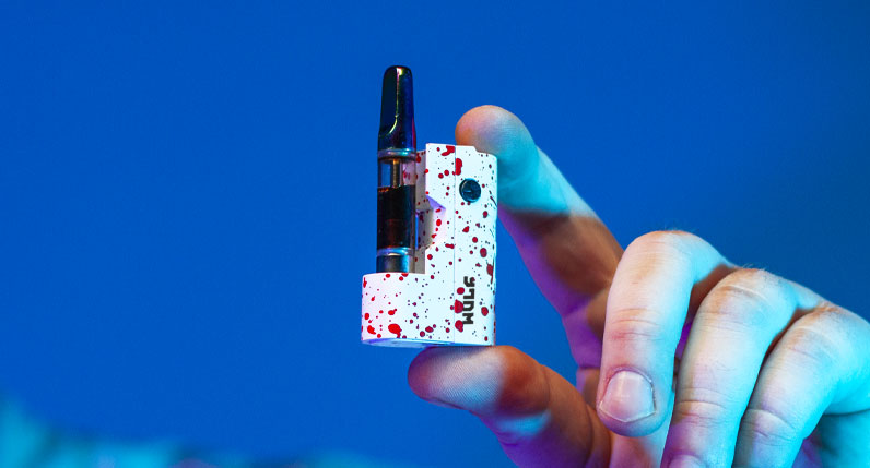 Man holding Wulf Micro Max in front of blue studio background