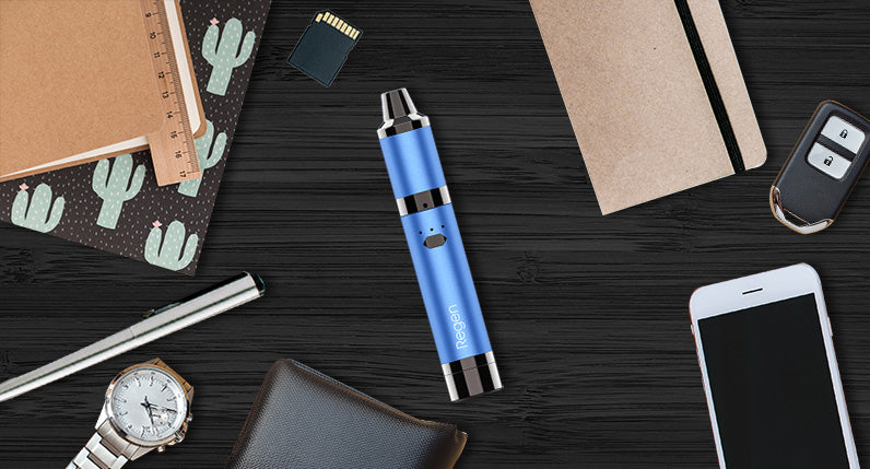 Yocan Regen laying down on black office desk surrounded by office supplies.