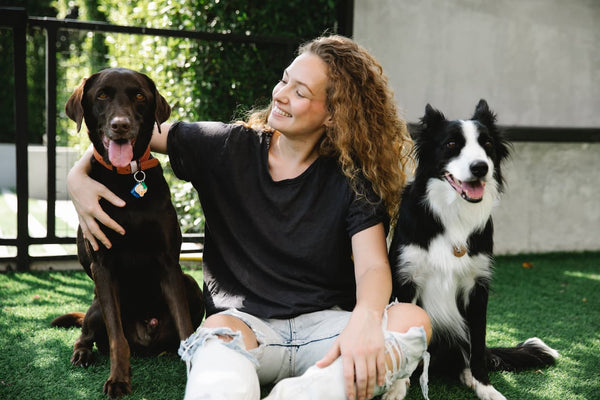 woman sitting next to her two dogs