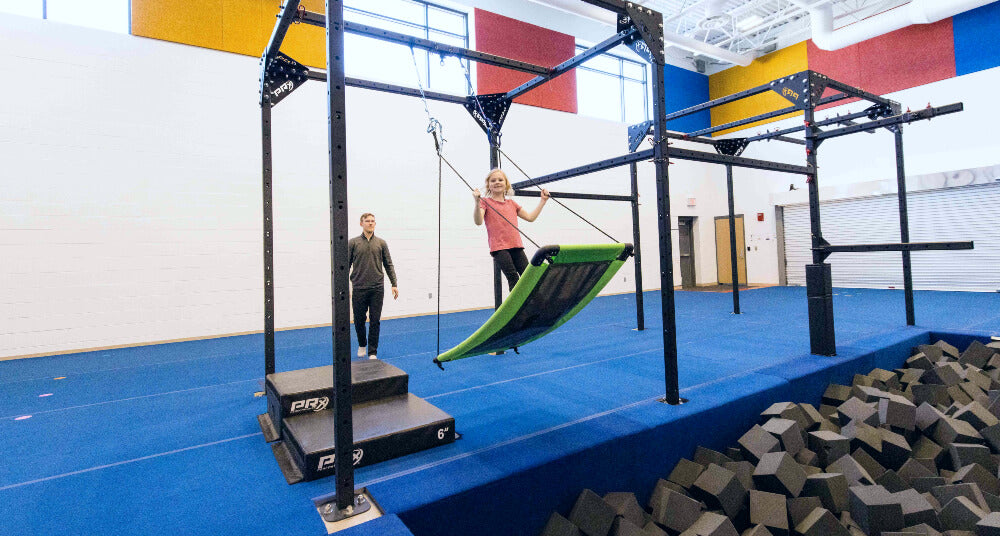 a girl standing on a platform swing