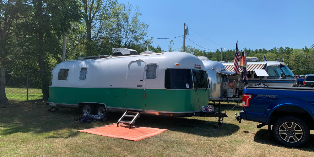 Zack the vintage Airstream Argosy that was renovated with a compost toilet with other vintage Airstreams in a field