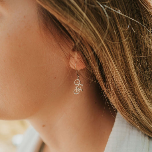 Girl wearing mountain bike earrings in stainless steel