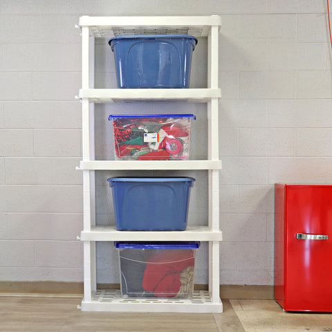 A white storage shelf sits on a wooden floor next to a white brick wall. On alternating shelves are blue/grey closed bins and clear closed bins with different items in them. Next to the shelf is a red mini fridge.