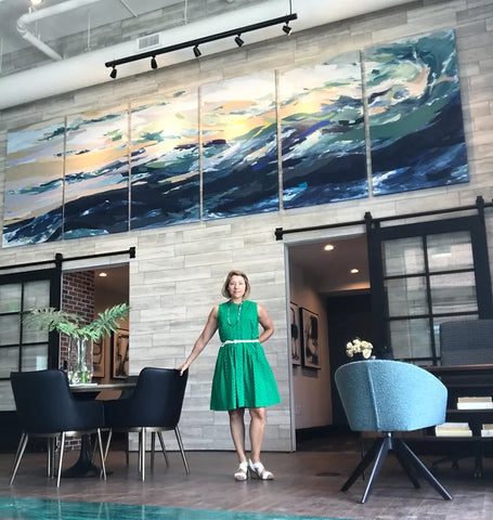 Karin Olah posing with her piece Sea Wall installed in Meeting Street Lofts