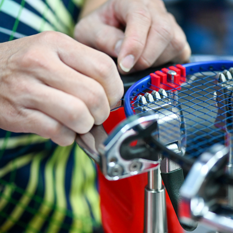 BADMINTON RACKET BEING STRUNG