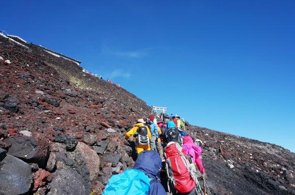 A line of hikers approaching the summit of Mount Fuji