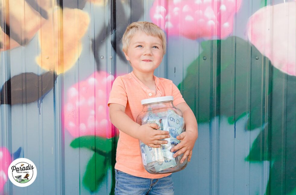 Smiling child holding jar full of fundraiser money