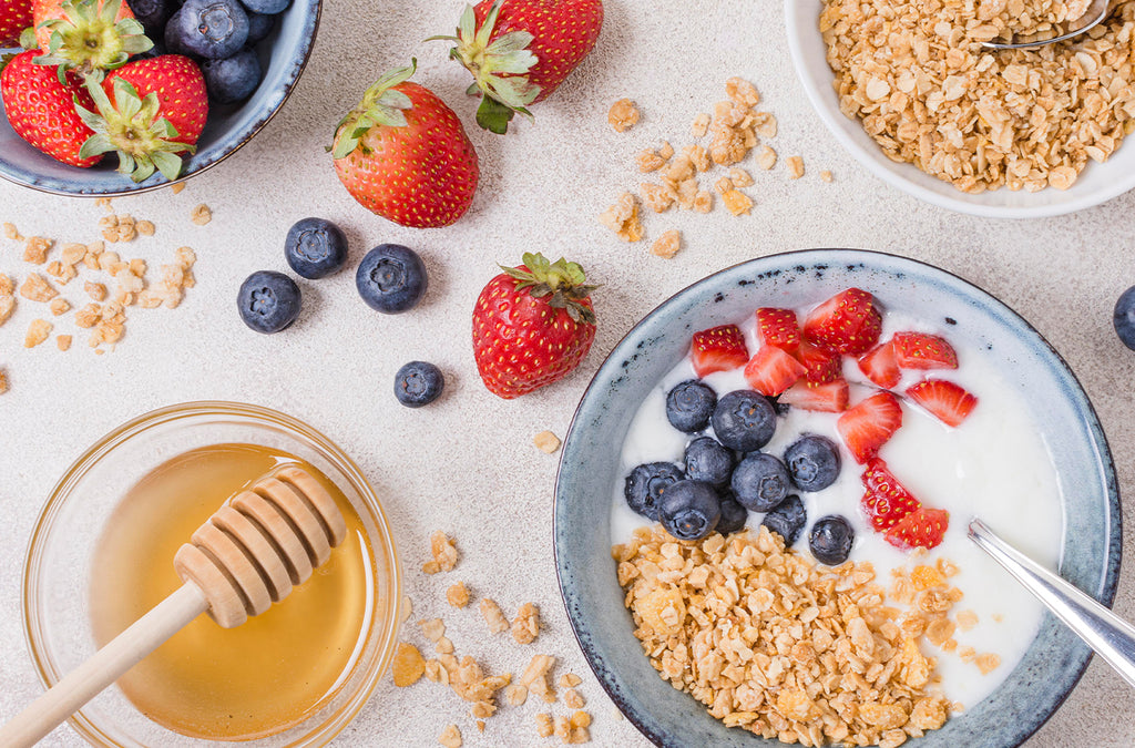 Honey breakfast bowl with granola, strawberries and blueberries