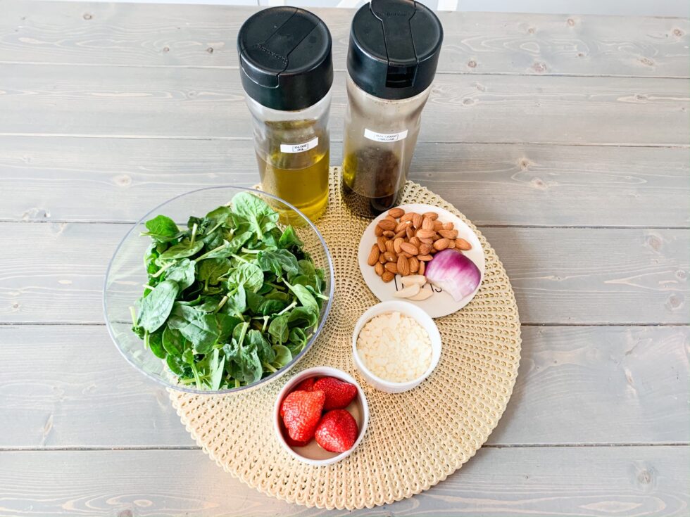 Image of the ingredients showing spinach, oils, strawberries and seasonings 