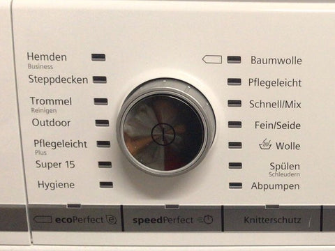 Programmwahlknopf einer Waschmaschine. Links und rechts neben dem Knopf sind LEDs angeordnet und die Programmbeschriftungen abgebracht.